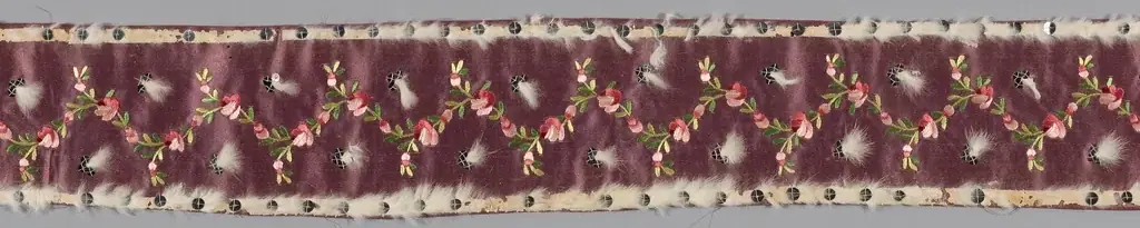 A length of plum velvet ribbon embroidered with small pink flowers